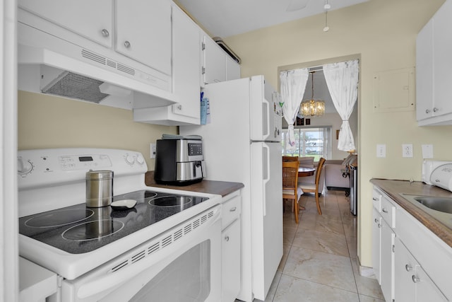 kitchen with an inviting chandelier, white appliances, decorative light fixtures, and white cabinets