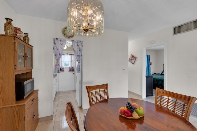 dining area with a notable chandelier and light tile patterned flooring