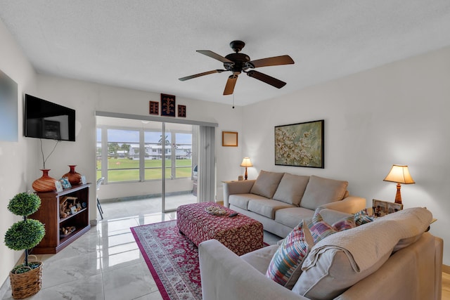 living room featuring ceiling fan and a textured ceiling