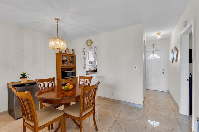 dining area featuring a chandelier and sink