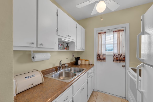 kitchen with sink, white appliances, light tile patterned floors, ceiling fan, and white cabinetry