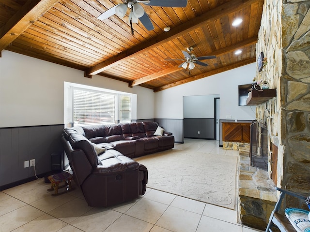 tiled living room featuring a stone fireplace, vaulted ceiling with beams, wooden ceiling, and ceiling fan