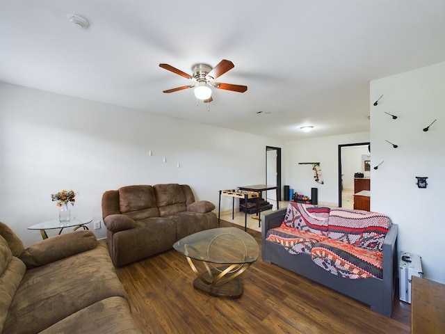 living room featuring dark wood-type flooring and ceiling fan