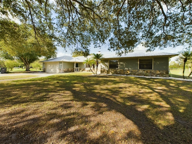 ranch-style home featuring a garage and a front lawn