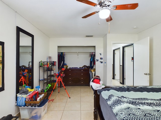 bedroom with ceiling fan, a closet, and light tile patterned floors