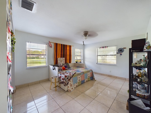 bedroom with multiple windows, light tile patterned flooring, and ceiling fan