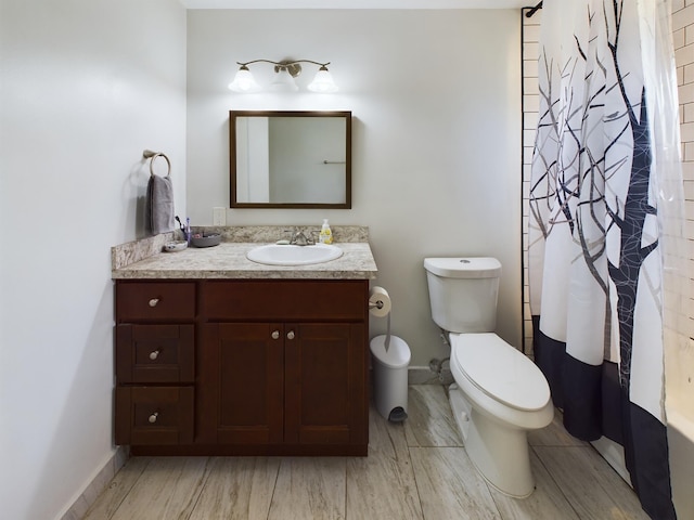 bathroom featuring vanity, walk in shower, and toilet