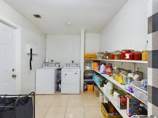 washroom with light tile patterned floors and washing machine and dryer