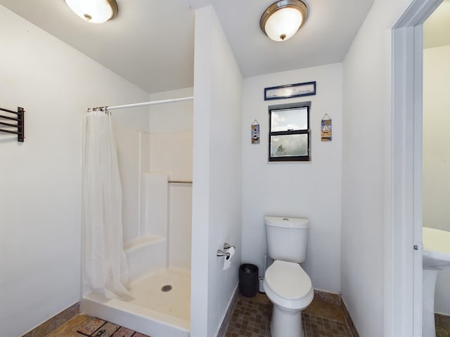 bathroom featuring toilet and walk in shower