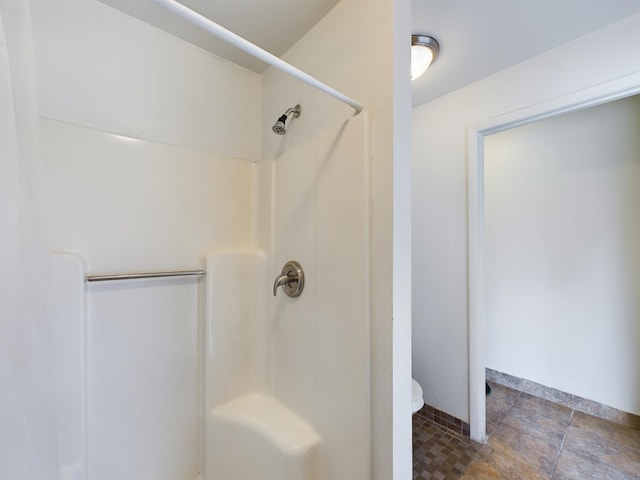 bathroom featuring a shower and toilet