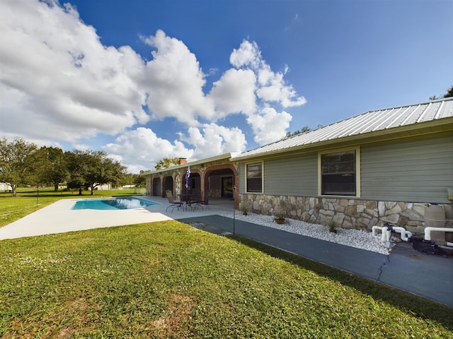 back of house with a yard and a patio