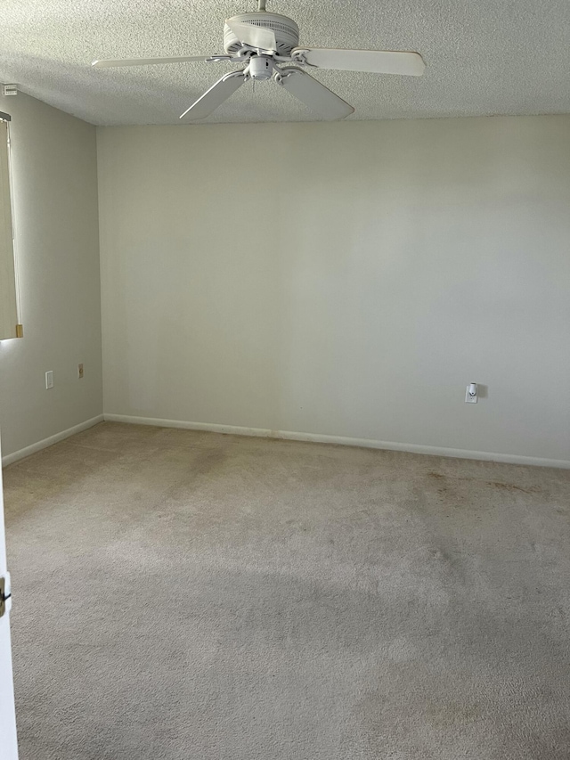 spare room featuring carpet, a textured ceiling, and ceiling fan