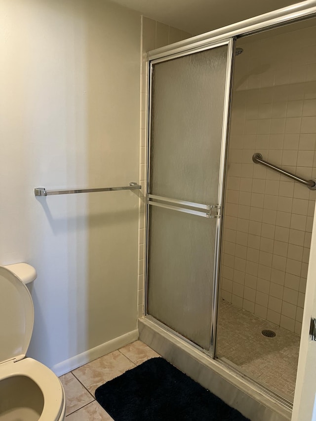 bathroom with an enclosed shower, tile patterned floors, and toilet