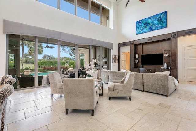 living room featuring a towering ceiling and ceiling fan