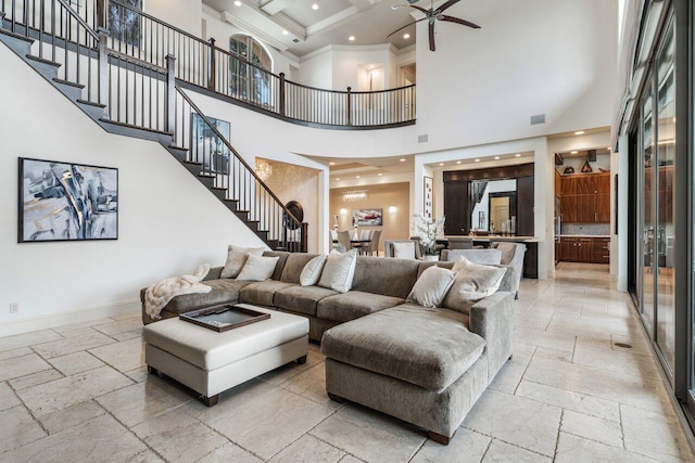 living room with a towering ceiling, ornamental molding, coffered ceiling, ceiling fan, and beam ceiling