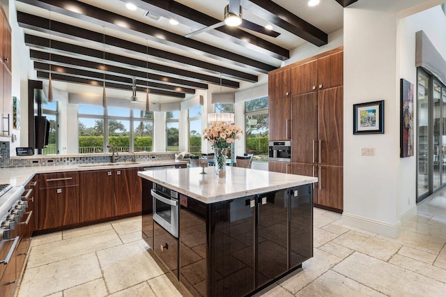 kitchen featuring stainless steel oven, a kitchen island, pendant lighting, beam ceiling, and decorative backsplash