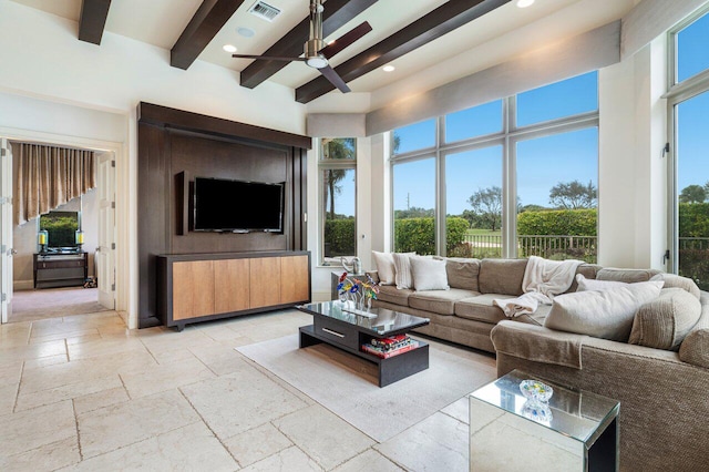 living room featuring ceiling fan, a towering ceiling, and beamed ceiling