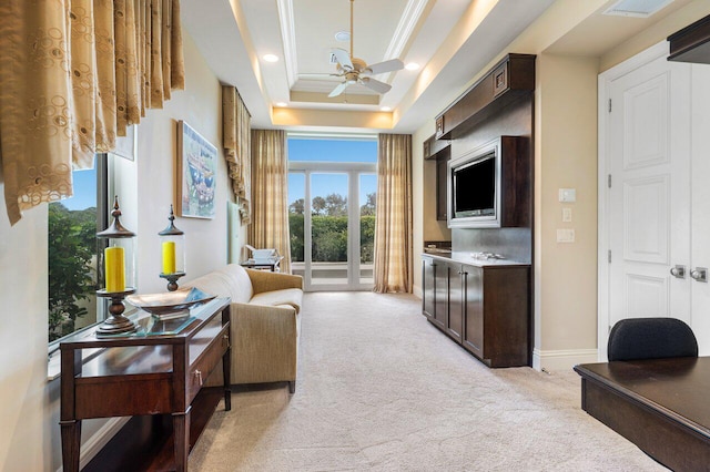 living room featuring ornamental molding, light colored carpet, a raised ceiling, and ceiling fan