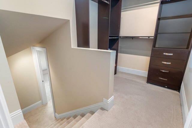 walk in closet featuring lofted ceiling and light carpet