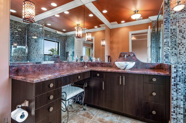 bathroom featuring tile patterned floors, ornamental molding, a shower with shower door, and vanity