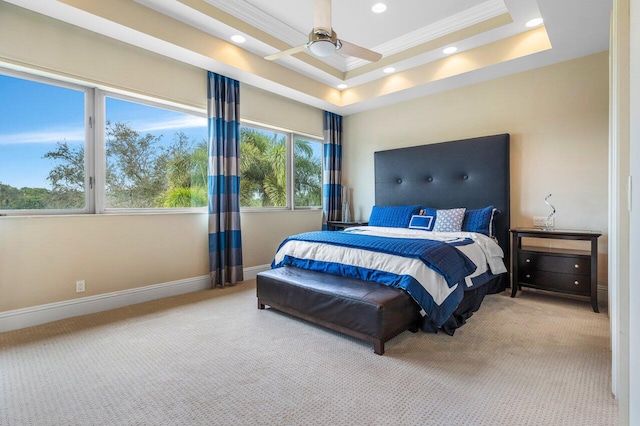 carpeted bedroom with crown molding, ceiling fan, and a tray ceiling