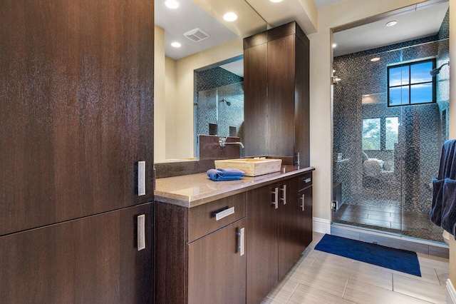 bathroom featuring walk in shower, vanity, and tile patterned flooring