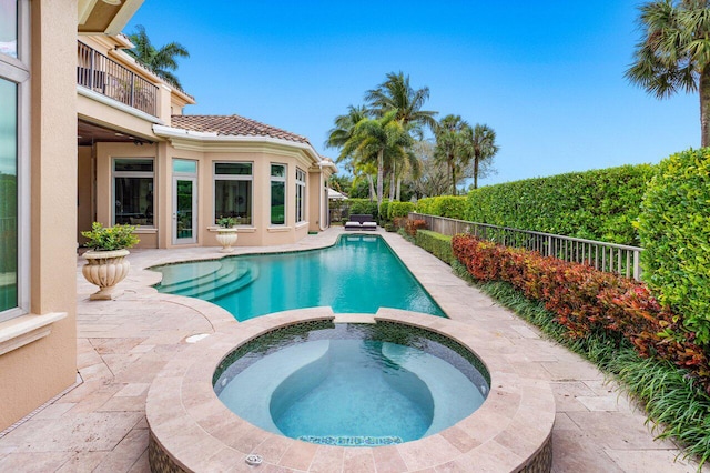 view of swimming pool featuring an in ground hot tub and a patio area