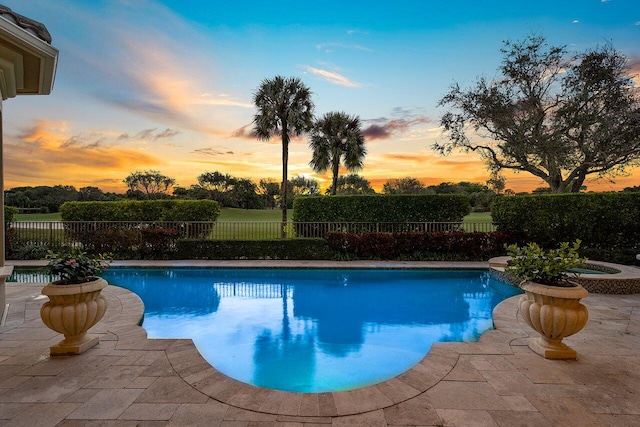 pool at dusk with a patio