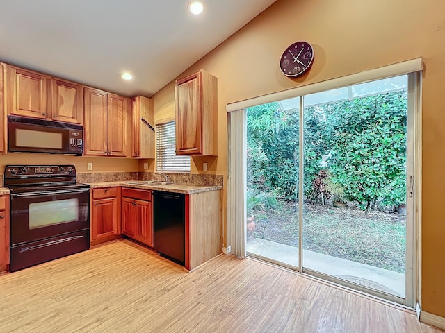 kitchen with light hardwood / wood-style flooring, sink, vaulted ceiling, and black appliances