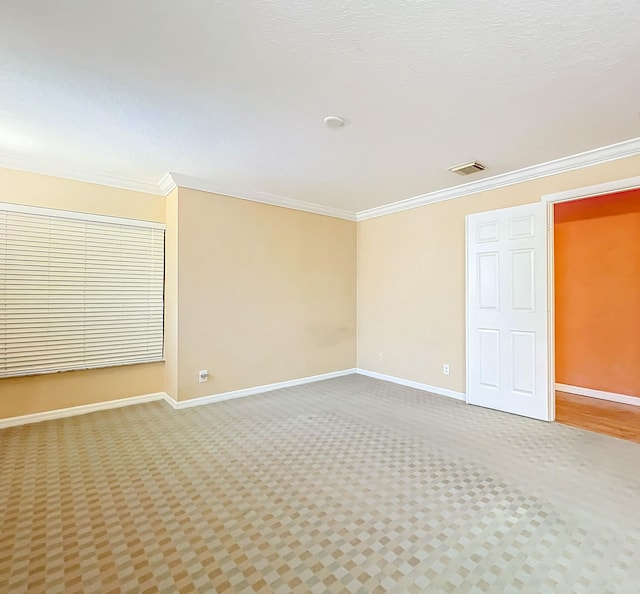 spare room featuring ornamental molding and carpet