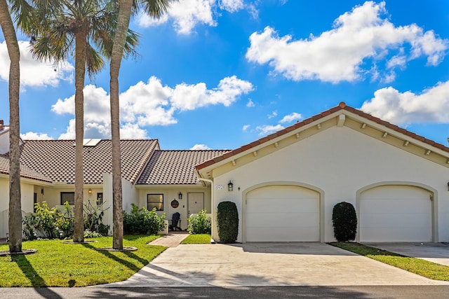 mediterranean / spanish-style home with a garage and a front lawn