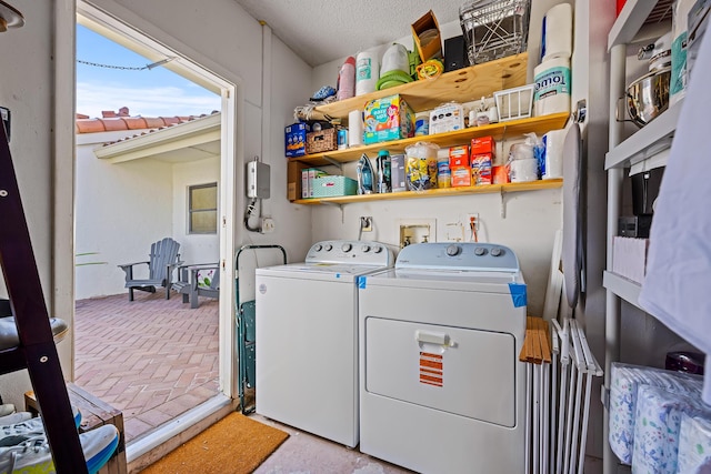 laundry area featuring washing machine and clothes dryer and a textured ceiling