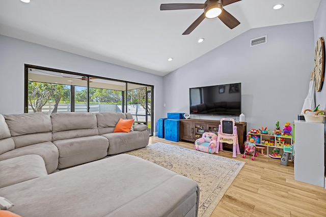 living room with ceiling fan, lofted ceiling, and light hardwood / wood-style floors