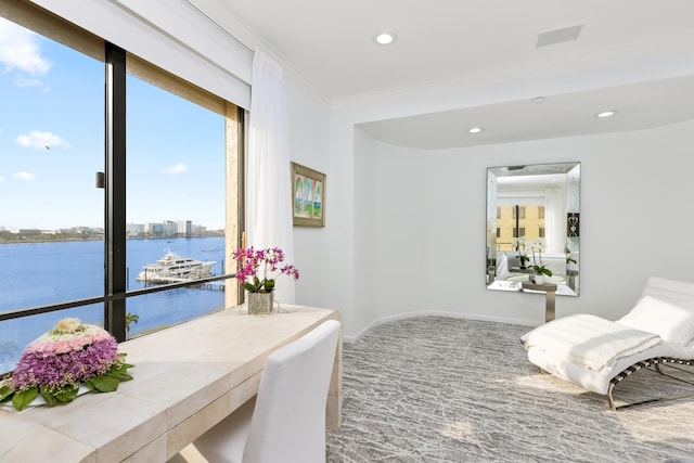 carpeted bedroom with a water view and crown molding