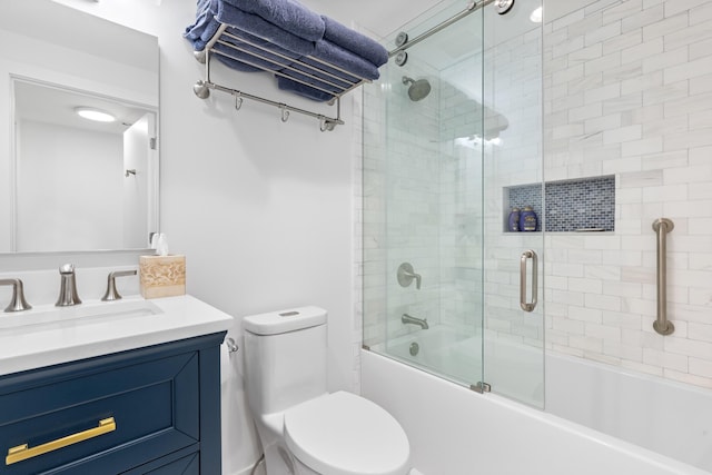 full bathroom featuring vanity, combined bath / shower with glass door, and toilet