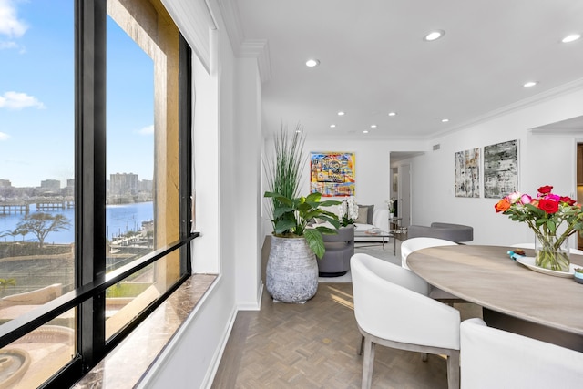 dining area with parquet floors, ornamental molding, and a water view