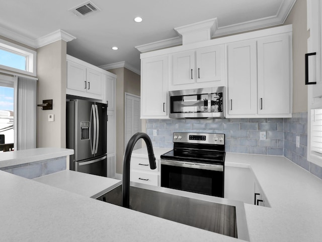 kitchen with sink, stainless steel appliances, ornamental molding, white cabinets, and decorative backsplash