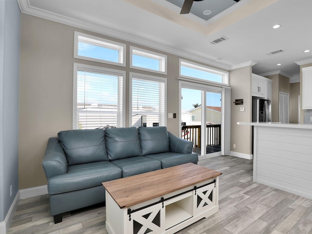 living room featuring ceiling fan, ornamental molding, and light hardwood / wood-style floors