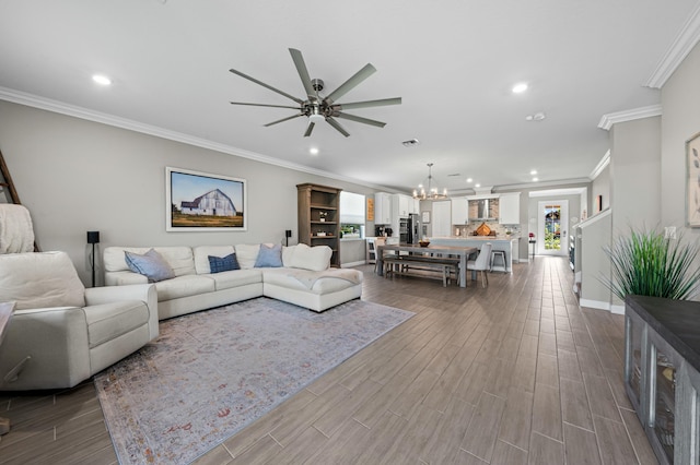 living room with crown molding, hardwood / wood-style flooring, and ceiling fan with notable chandelier