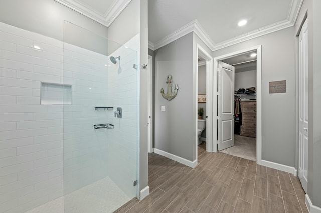 bathroom featuring crown molding, tiled shower, and toilet