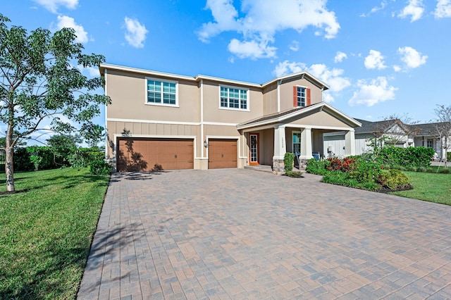 view of front of home with a garage, covered porch, and a front lawn