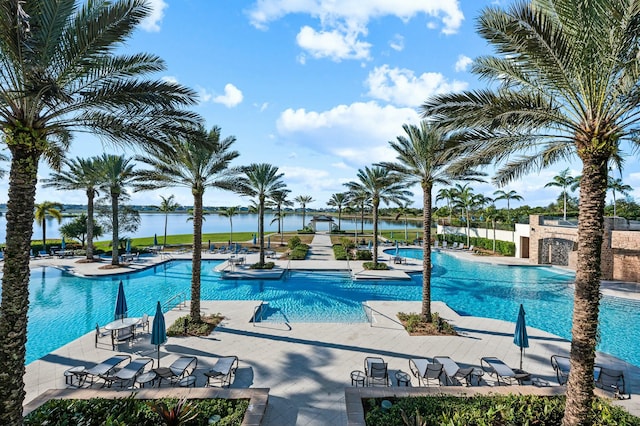 view of swimming pool with a water view and a patio area