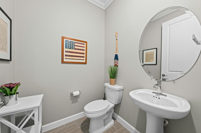 bathroom with crown molding and toilet