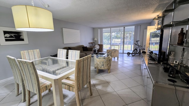 dining space with light tile patterned floors and a textured ceiling