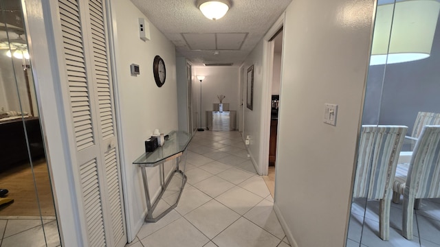 hallway with light tile patterned floors and a textured ceiling