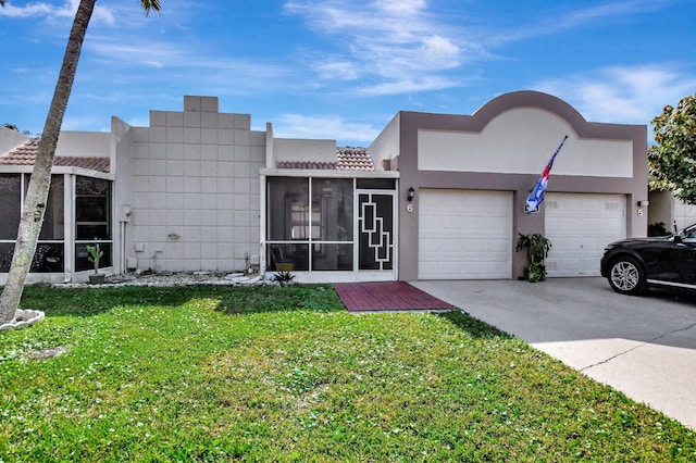 view of front facade featuring a garage, a sunroom, and a front lawn