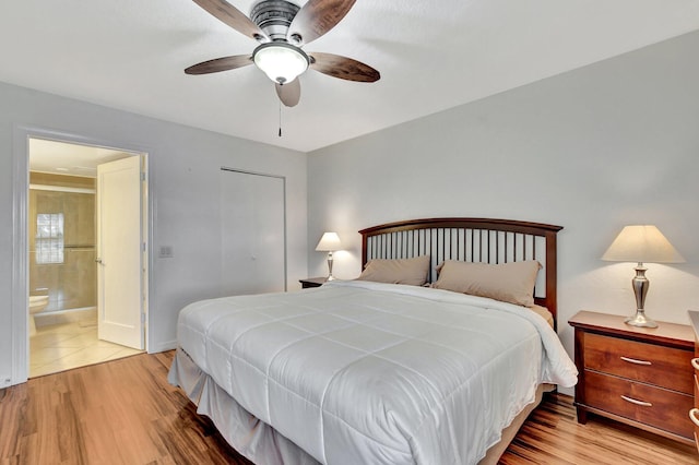 bedroom featuring light hardwood / wood-style floors, ceiling fan, and ensuite bathroom