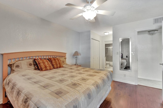 bedroom with ceiling fan, ensuite bath, dark hardwood / wood-style flooring, and a textured ceiling