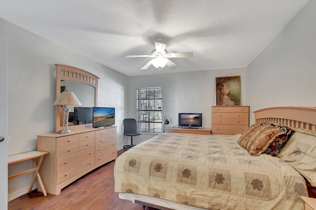 bedroom featuring ceiling fan, wood-type flooring, and a textured ceiling