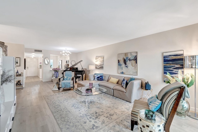 living room featuring light hardwood / wood-style flooring and a chandelier